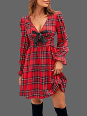 Plaid Holiday Mini Dress – Smocked & Ruffled displayed on a model, featuring a bow-tie front and ruffled hem.