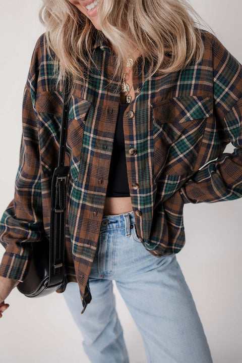 Oversized brown plaid button-up shacket with rolled sleeves paired with denim jeans and neutral top