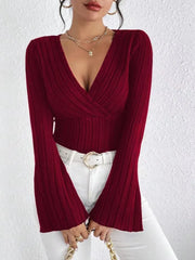 Model wearing a Ribbed Flare Sleeve Top in burgundy, featuring a deep V-neck and flared sleeves.