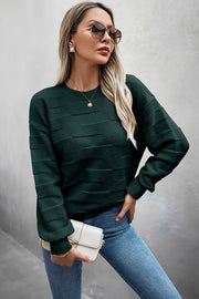 Woman in sunglasses wearing a Classic Round Neck Loose Knit Sweater with long sleeves and jeans.