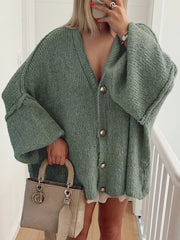 Woman wearing a green Buttoned Blouse with oversized sleeves and a stylish handbag.
