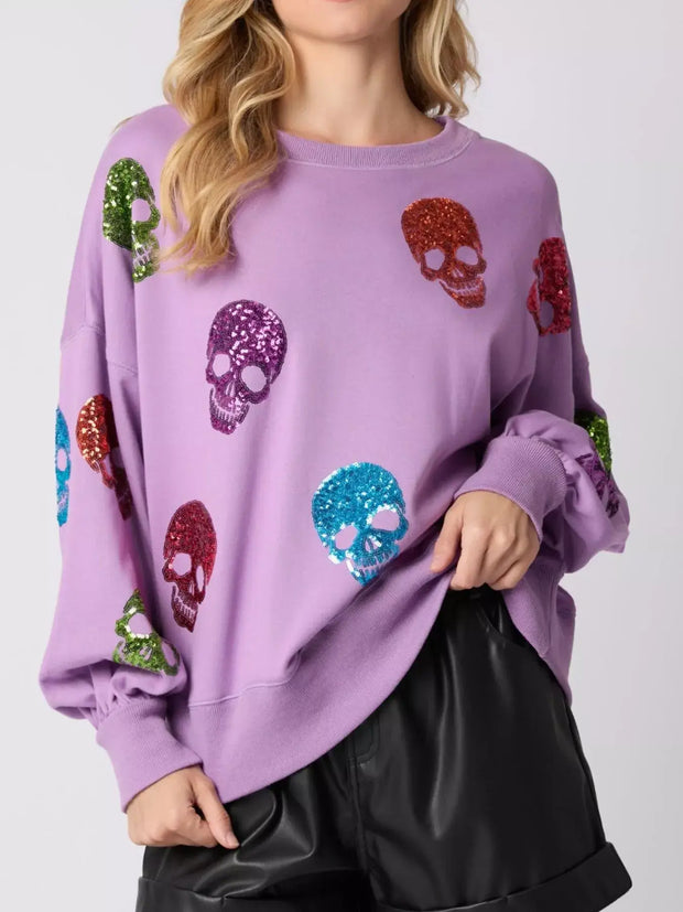 Halloween Colorful Skull Sequin Oversized Sweatshirt with vibrant sequined skulls on a lilac background.