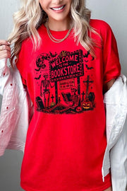 Bookstore Skeleton Halloween Graphic Heavy Cotton Tee featuring playful skeleton design on vibrant red background.