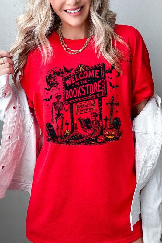 Bookstore Skeleton Halloween Graphic Heavy Cotton Tee featuring playful skeleton design on vibrant red background.