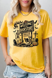 Bookstore Skeleton Halloween Graphic Heavy Cotton Tee featuring a playful skeleton design on a yellow background.