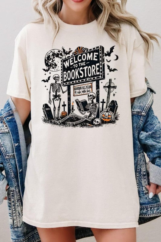 Bookstore Skeleton Halloween Graphic Heavy Cotton Tee featuring playful skeletons and a spooky bookstore sign design.