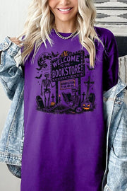 Bookstore Skeleton Halloween Graphic Heavy Cotton Tee featuring a spooky skeleton design on a vibrant purple shirt.