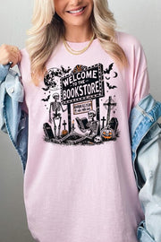 Bookstore Skeleton Halloween Graphic Heavy Cotton Tee featuring playful skeletons and a spooky bookstore sign.
