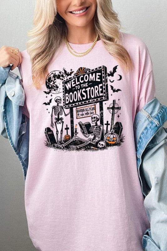 Bookstore Skeleton Halloween Graphic Heavy Cotton Tee featuring playful skeletons and a spooky bookstore sign.