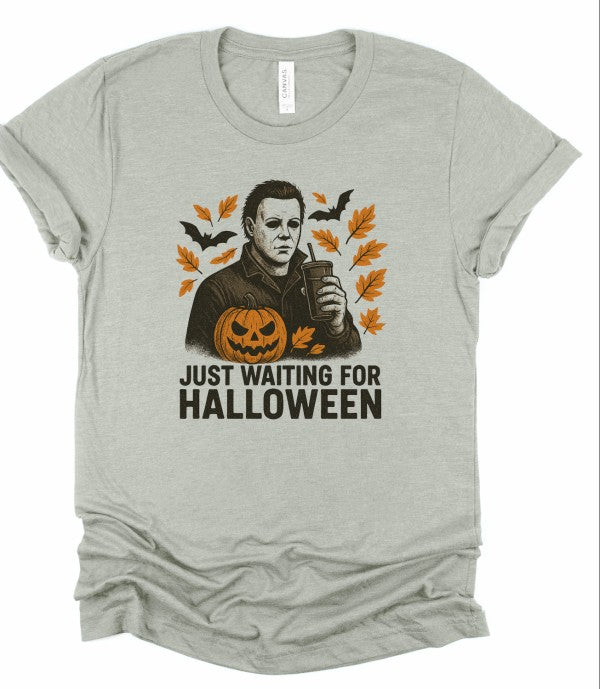 Just Waiting Halloween Graphic Tee featuring a spooky design with a pumpkin and fall leaves.