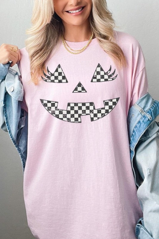 Checker Pumpkin Face Graphic Heavy Cotton Tee worn by a smiling woman, featuring a playful checker pumpkin face design.