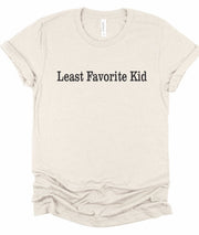 Least Favorite Kid Short Sleeve Graphic Tee in soft beige fabric with bold text.