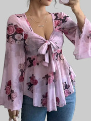 Floral Tie-Front Blouse worn by a model, featuring a v-neckline and long sleeves with a floral pattern.