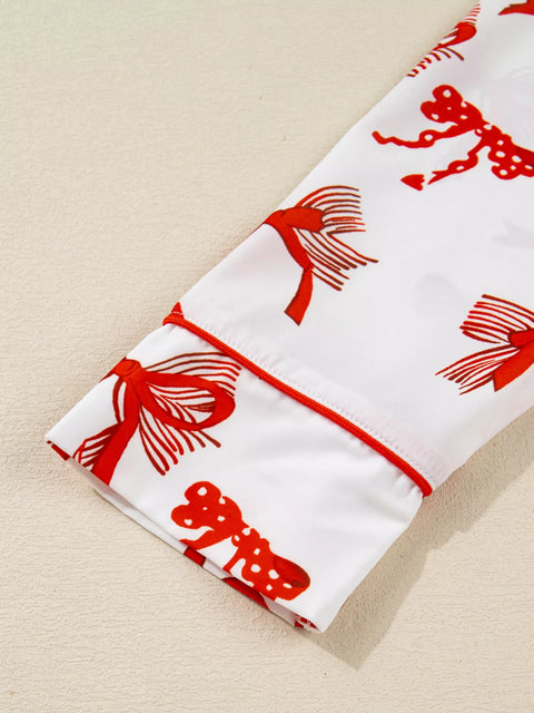 Close-up of the sleeve of a Buttoned Two-Piece Set featuring red bow patterns on a white background.