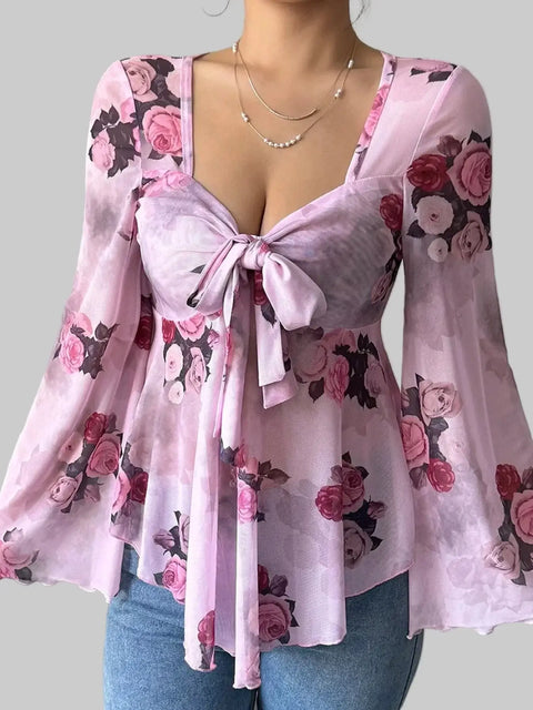 Floral Tie-Front Blouse featuring a v-neckline, fluttery sleeves, and a tie front, designed in pink floral fabric.