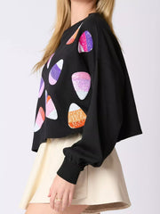 Halloween Candy Sequin Long-Sleeve Sweatshirt worn with a stylish skirt, showcasing colorful sequin candy detail.