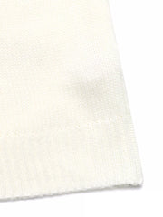 close up of A model wearing a Cozy Geometric Knit Round Neck Sweater, paired with light blue jeans and white sneakers, posing with a brown handbag.