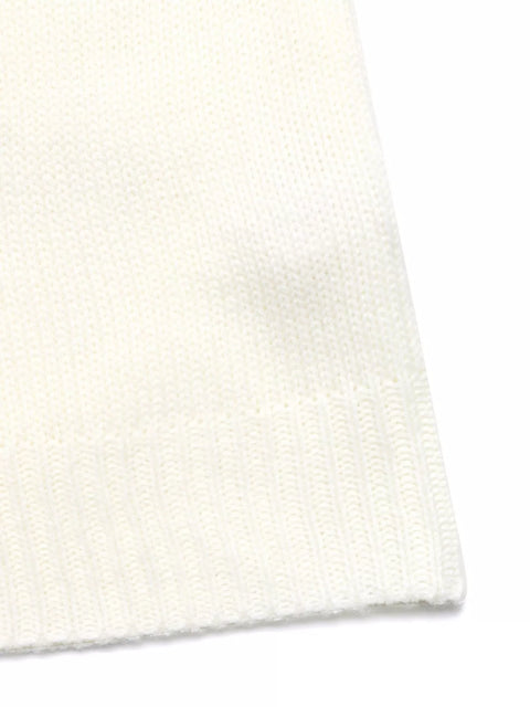 close up of A model wearing a Cozy Geometric Knit Round Neck Sweater, paired with light blue jeans and white sneakers, posing with a brown handbag.