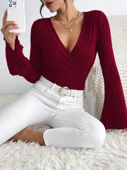 Model wearing a Ribbed Flare Sleeve Top in burgundy with white jeans, posing and taking a selfie.
