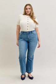 Model wearing Judy Blue High-Waist Straight Leg Jeans – Tummy Control with a white top and blue shoes.