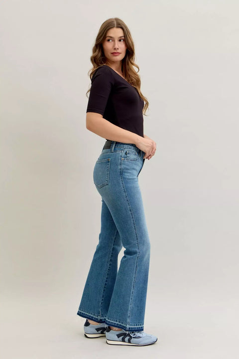 Judy Blue High-Waist Straight Leg Jeans – Tummy Control model posing in light blue jeans with black top.