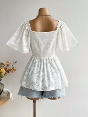 Back view of Floral Tie-Front Smocked Back Flutter Sleeve Blouse  on mannequin featuring tie front, smocked waist, and feminine flutter sleeves