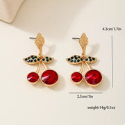 18K Gold-Plated Cherry Drop Earrings – Playful Statement Jewelry featuring red resin cherries and gold leaf accents.