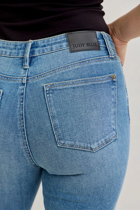 Back view of a woman wearing Judy Blue High-Waist Straight Leg Jeans, showcasing the denim and brand logo.