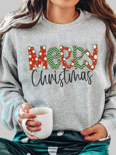 Model wearing Merry Christmas Letter Sweatshirt holding a mug — festive lettering and cozy fleece design perfect for holiday mornings