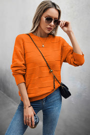 Classic Round Neck Loose Knit Sweater in vibrant orange, styled for a modern casual look with sunglasses and a chic bag.