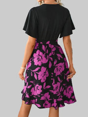 Back view of printed tie-waist mini dress showing purple floral skirt and short sleeves