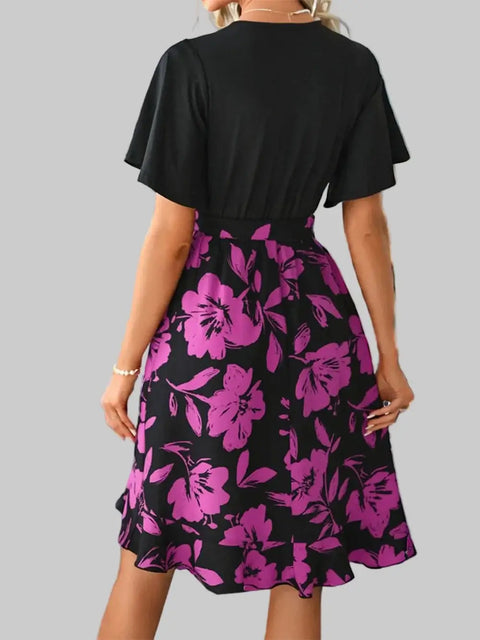 Back view of printed tie-waist mini dress showing purple floral skirt and short sleeves
