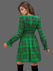 Back view of the Plaid Holiday Mini Dress – Smocked & Ruffled in green with a smocked waist and ruffled hem.