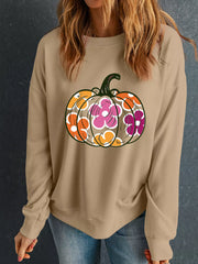 Woman wearing a Halloween Floral Pumpkin Graphic Drop-Shoulder Sweatshirt with a colorful floral pumpkin design.