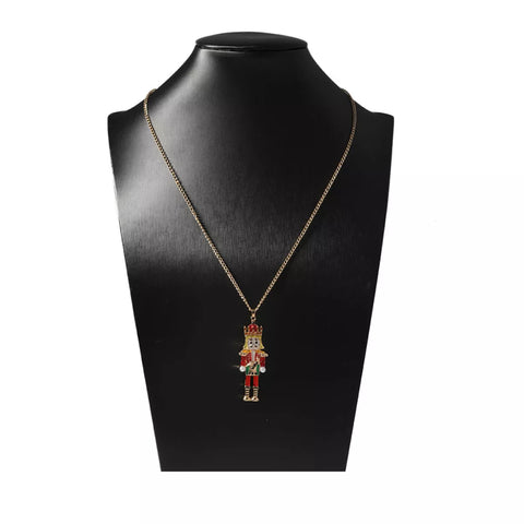 18K Gold Nutcracker Pendant Necklace displayed on a black necklace stand, showcasing its festive design.