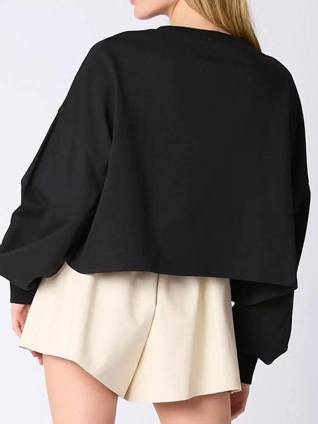 Back view of a black Halloween Candy Sequin Long-Sleeve Sweatshirt styled with a cute skirt.