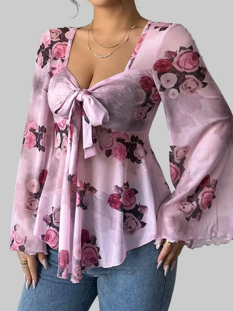 Floral Tie-Front Blouse featuring a v-neckline and flutter sleeves, designed with pink floral patterns for a romantic look.