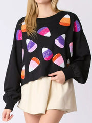Model wearing Halloween Candy Sequin Long-Sleeve Sweatshirt with colorful candy designs.