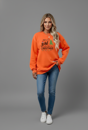 Woman in an orange Letter Graphic Round Neck Sweatshirt with festive Christmas design and blue jeans.