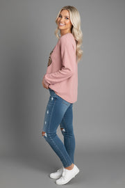 Side view of a women wearing a Heart Ribbed Round Neck Sweatshirt worn by a model, featuring leopard print hearts with a cozy pink hue.