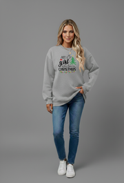 Woman wearing Letter Graphic Round Neck Sweatshirt with Christmas design and jeans against a gray background.
