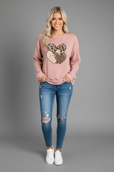 Heart Ribbed Round Neck Sweatshirt worn by a model, featuring leopard print hearts with a cozy pink hue.