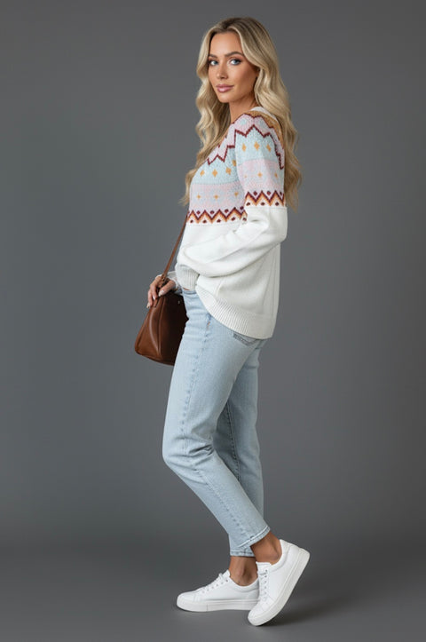 A side view of a model wearing a Cozy Geometric Knit Round Neck Sweater, paired with light blue jeans and white sneakers, posing with a brown handbag.