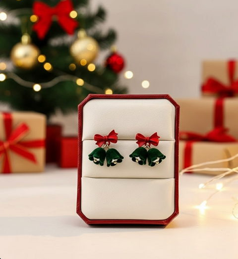 Velvet Bell Earrings with Bow displayed on a jewelry stand with holiday decorations in the background.