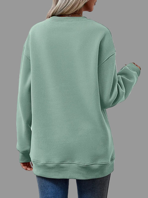 Back view of a woman wearing a mint green Letter Graphic Round Neck Sweatshirt with relaxed fit.