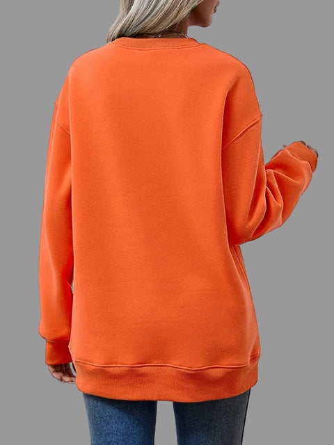 Back view of a woman wearing a Letter Graphic Round Neck Sweatshirt in vibrant orange, showcasing its relaxed fit and long sleeves.