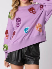 Halloween Colorful Skull Sequin Oversized Sweatshirt featuring multicolored sequin skulls on a lavender background.