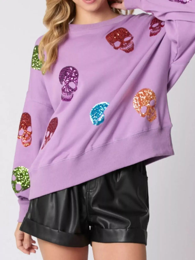 Halloween Colorful Skull Sequin Oversized Sweatshirt featuring multicolored sequin skulls on a lavender background.