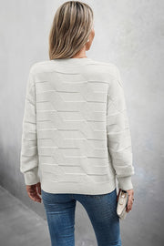 Back view of a woman wearing a Classic Round Neck Loose Knit Sweater paired with jeans, highlighting a relaxed fit.