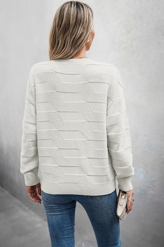 Back view of a woman wearing a Classic Round Neck Loose Knit Sweater paired with jeans, highlighting a relaxed fit.